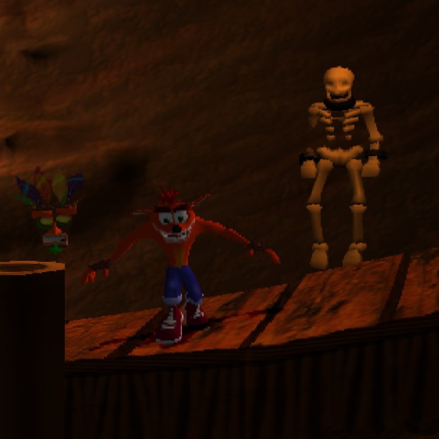 A screenshot from the game, showing Crash with his arms outstretched standing next to a crude model of a human skeleton. Crash wears a maniacal grin