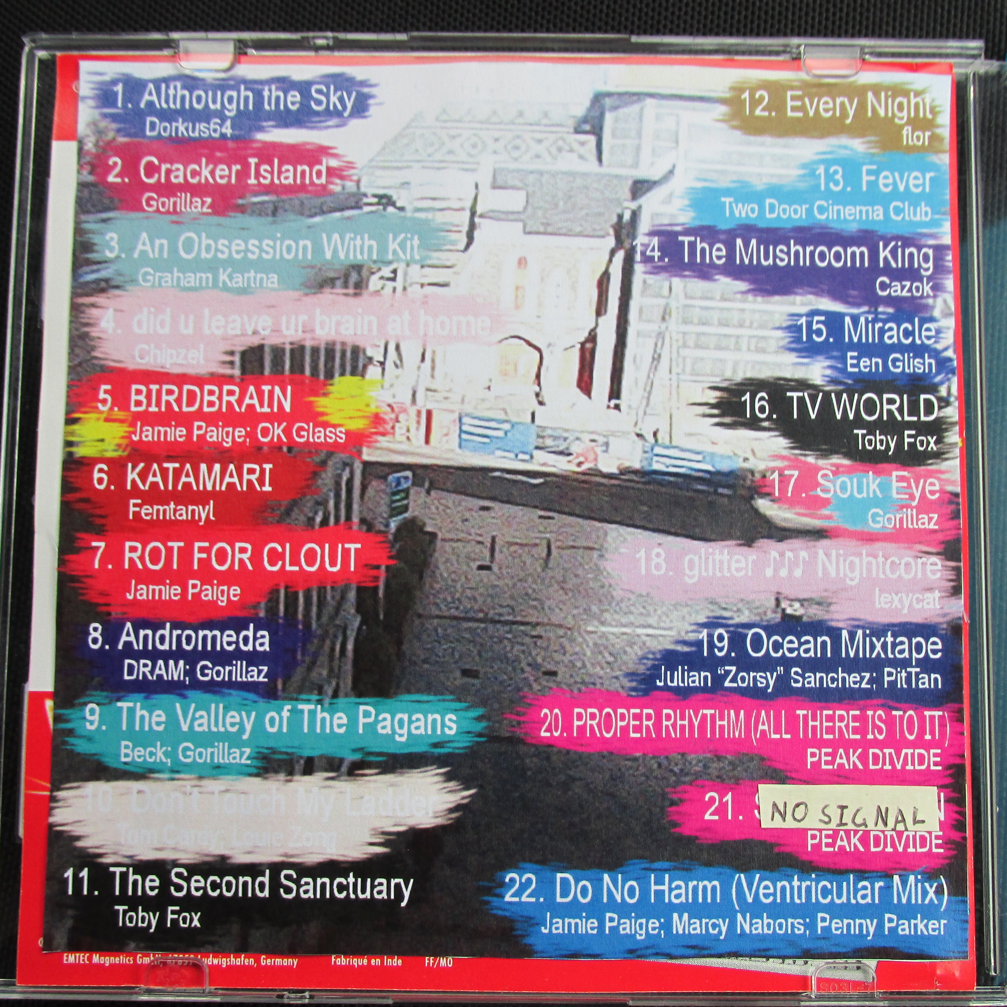Inside cover for the CD, A grainy low quality photo of a city street. The track names and numbers are lazily splattered over top. A piece of sticky note covers one of the tracks.